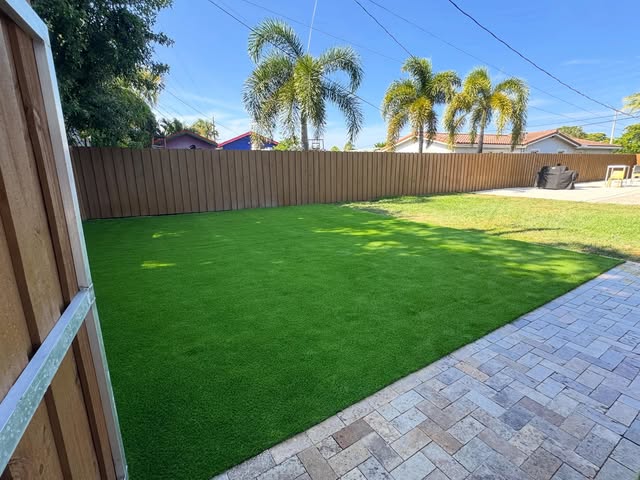 Artificial turf backyard with paver patio border