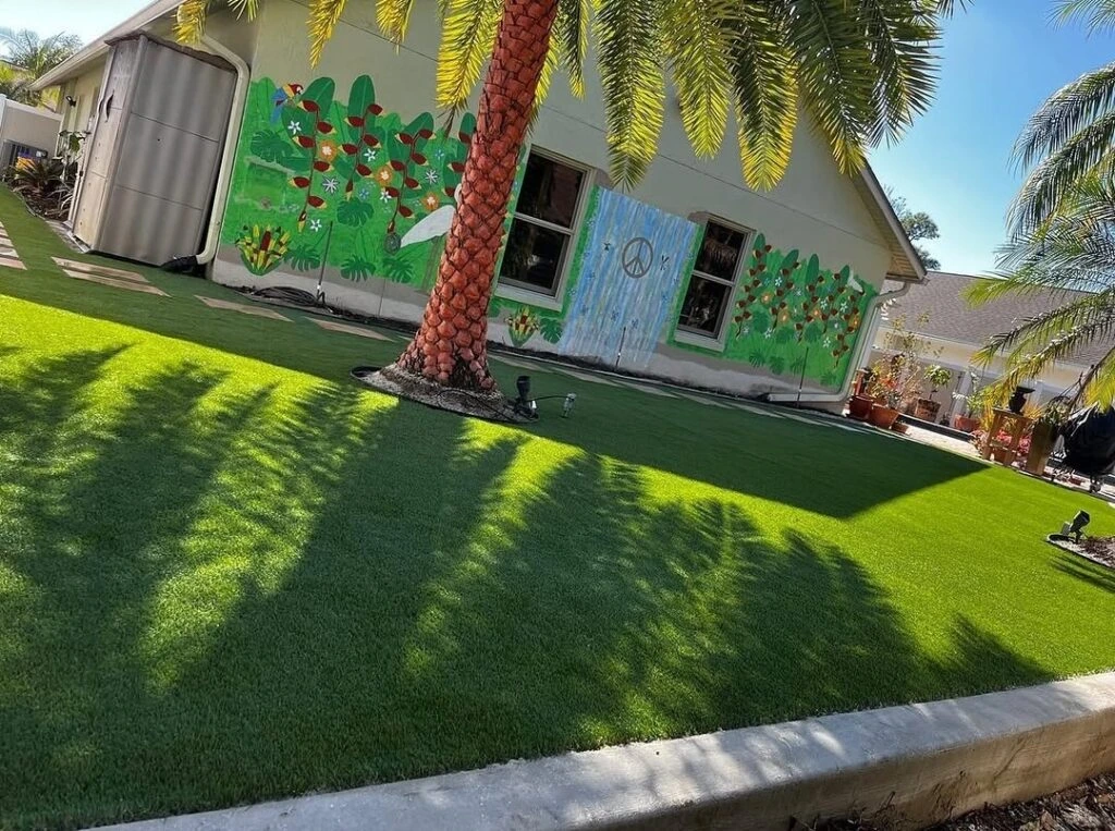 Artificial turf front yard installation with palm tree