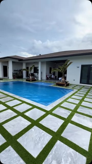 Artificial turf and paver checkerboard pool deck installation