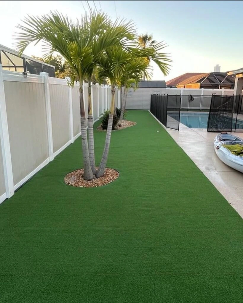 Artificial turf side yard installation with palm trees near pool