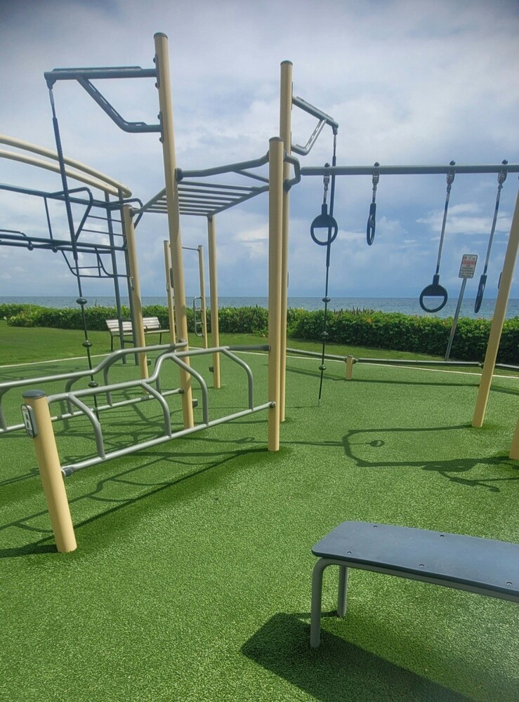 Outdoor artificial turf gym with pull-up bars and gymnastic rings overlooking the ocean in Deerfield Beach, FL